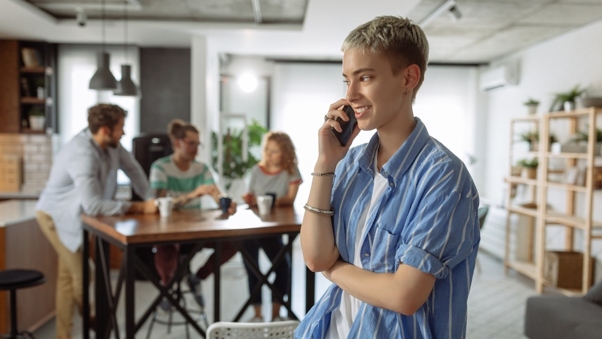 Someone on the phone while around their friends.