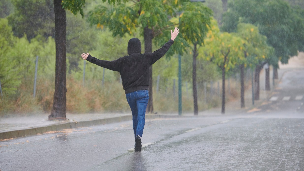 Feature image of shou ga nai showing man walking in the rain without an umbrella