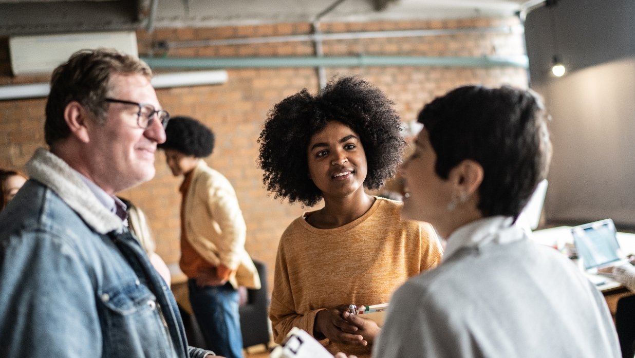 3 people talking at some kind of public event.