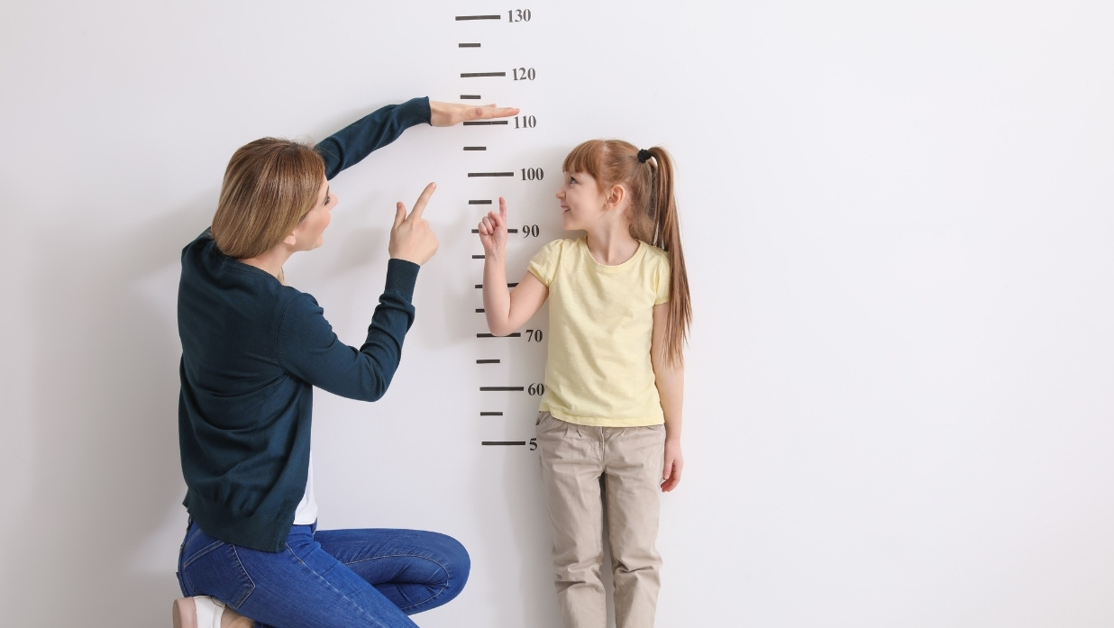 A child's height being measured by a parent.
