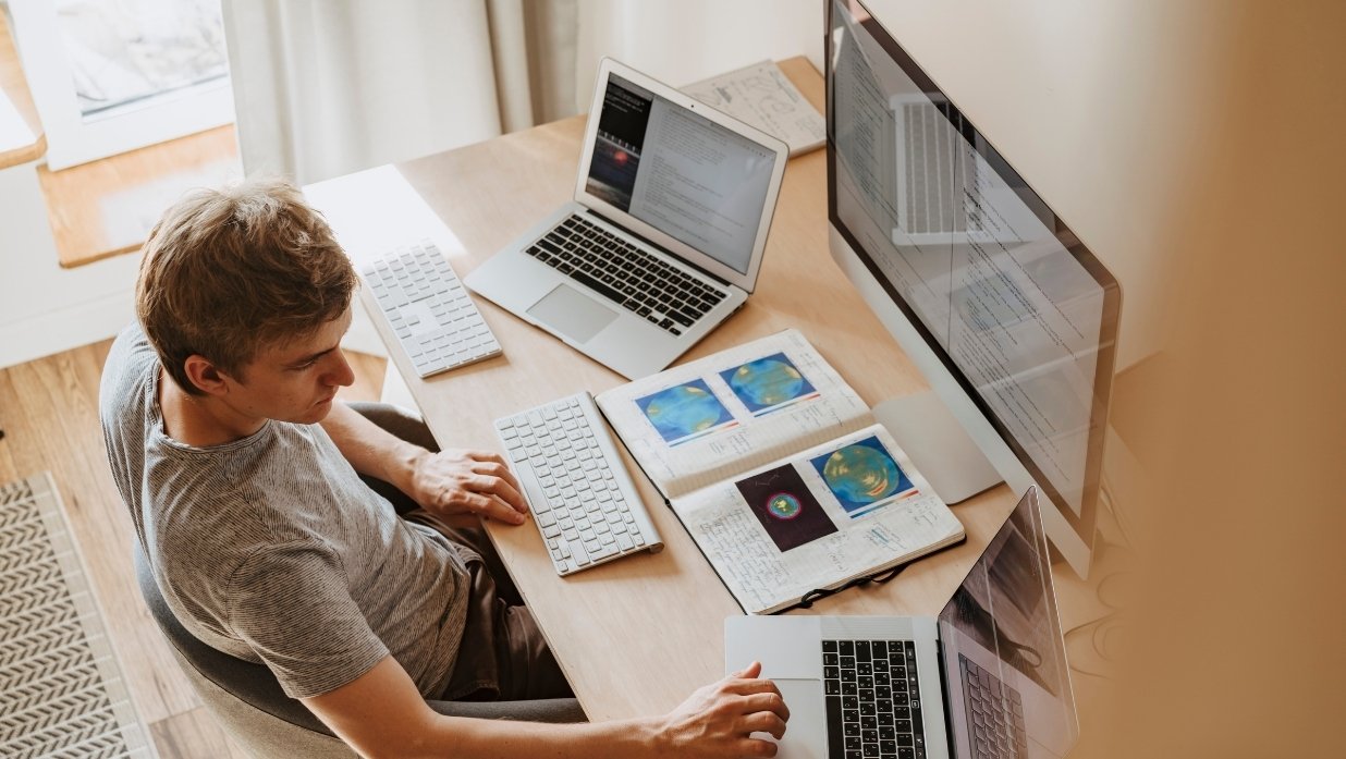 Someone with 2 laptops, a monitor, and books around him. Coming off an intellect, but does he know anything about PCs?