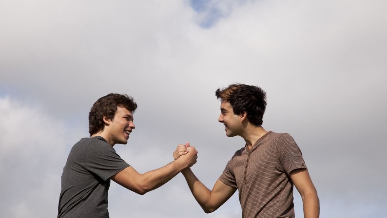 2 male friends dabbing each other up.