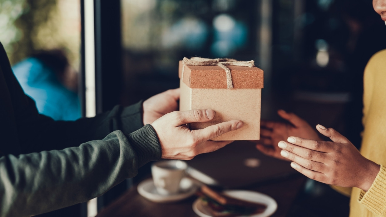 A person giving someone else a gift.