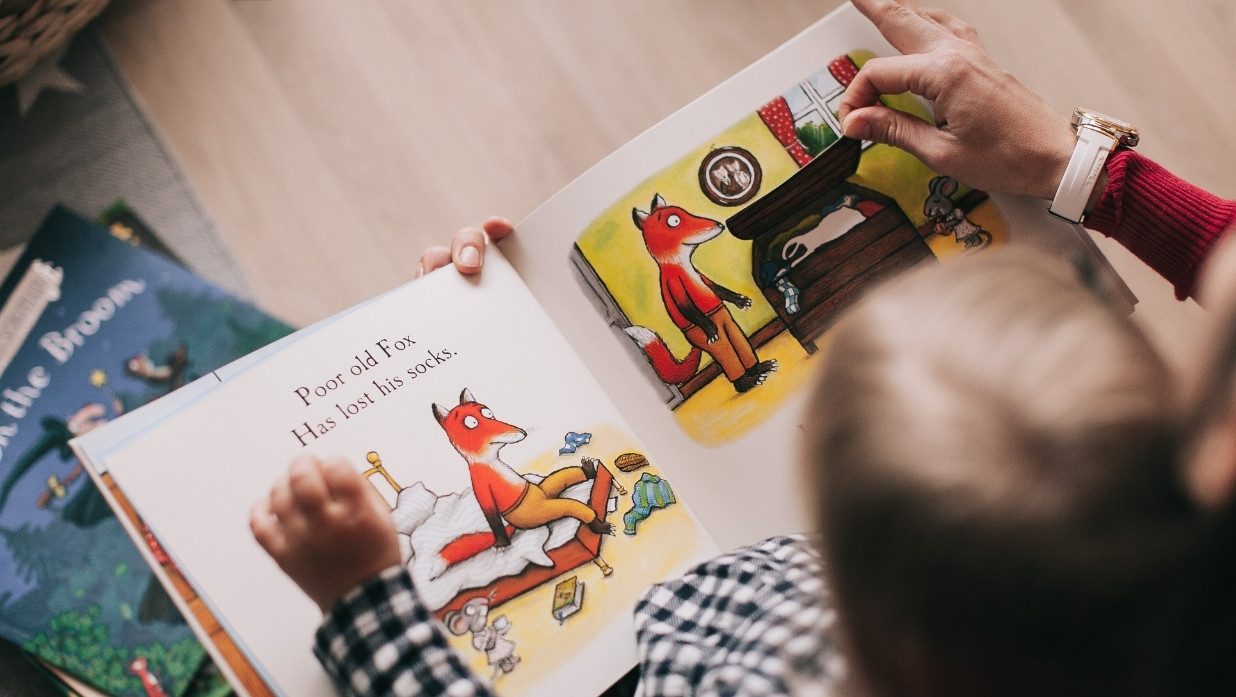 Children's book that has a fox on it. Child is reading/watching.