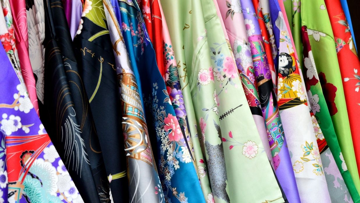 Many kimonos hung up next to eachother.