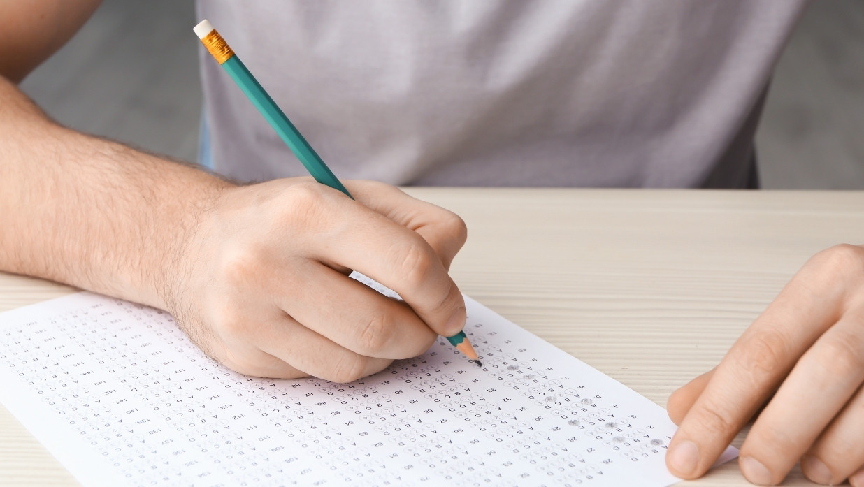 A person taking an exam, paper and pencil style.