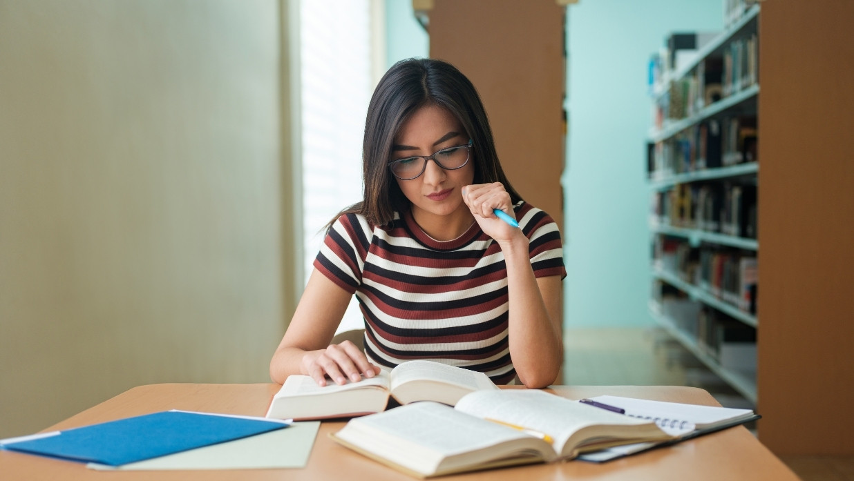 Woman studying her textbooks at a library