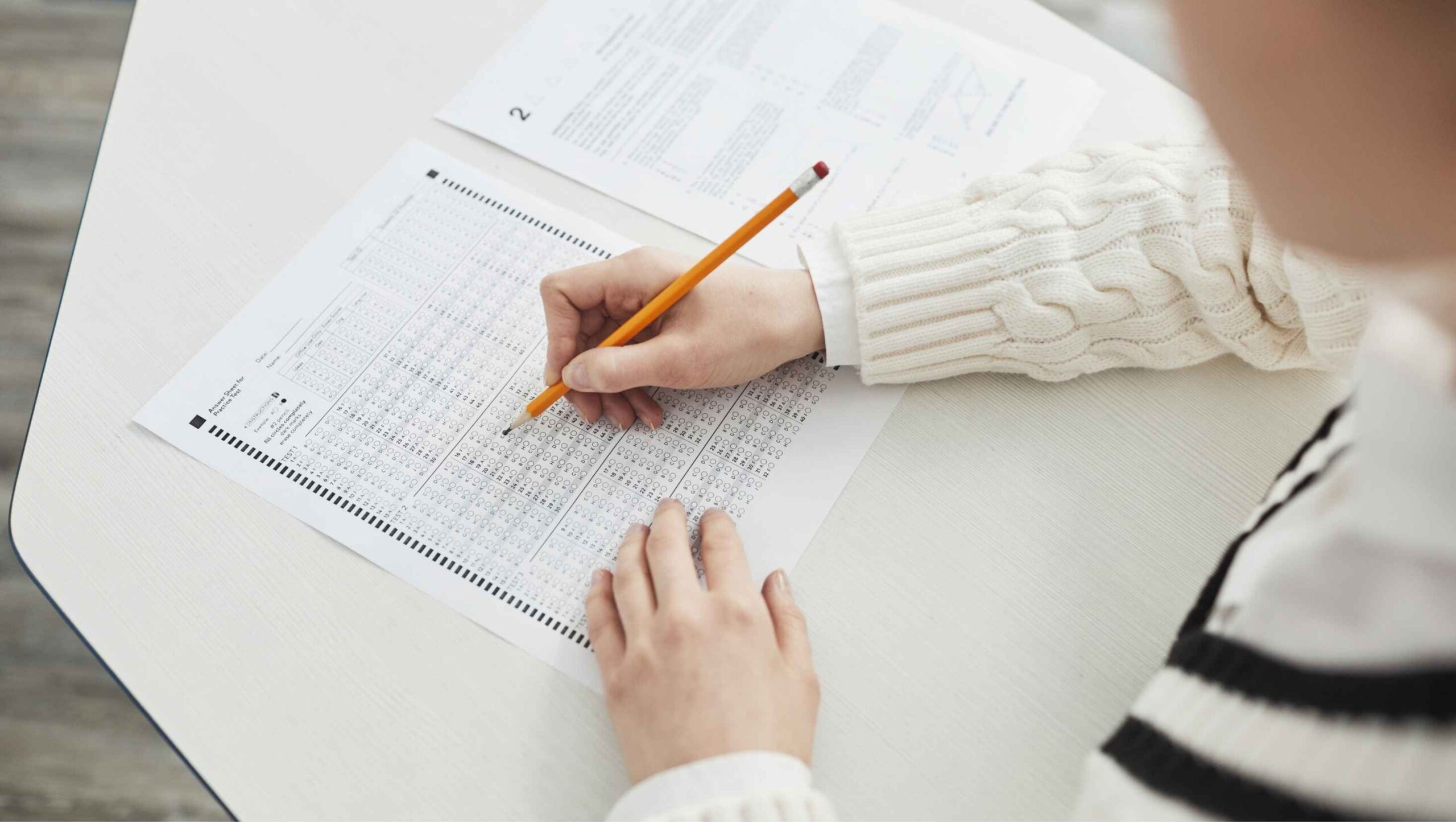 person writing an answer to jlpt answer sheet