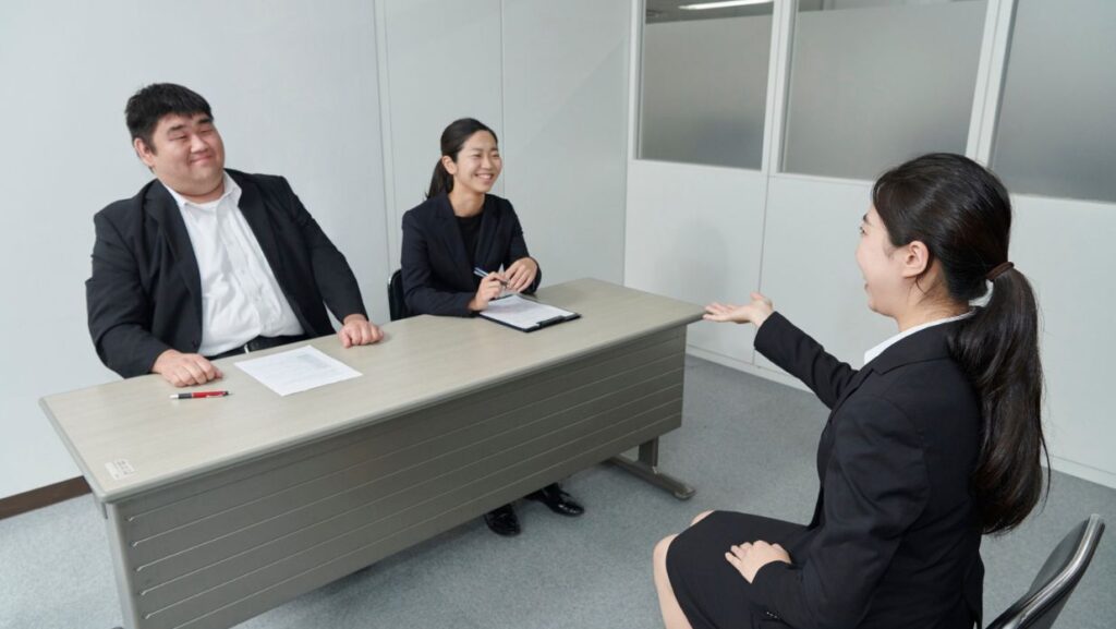 a woman being interviewed by 2 japanese people
