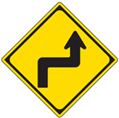 Japanese road sign indicating sharp turns ahead