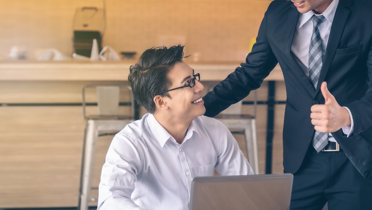 feature image of blog showing a colleague complimenting eachother with a thumbs up